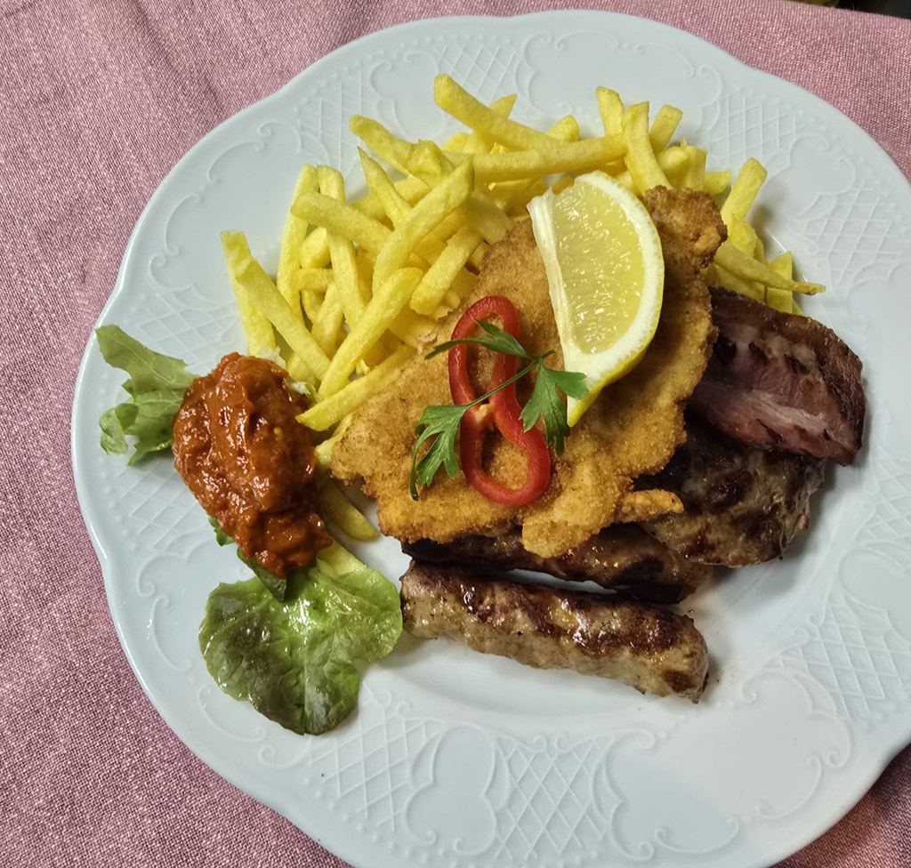 Teller mit Schnitzel, Cevapcici, Steak, Pommes frites und Ajvar